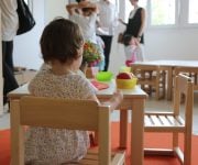 Una bambina davanti a un piatto