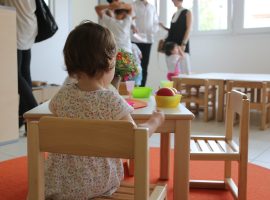 Una bambina davanti a un piatto