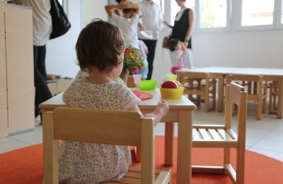 Una bambina davanti a un piatto